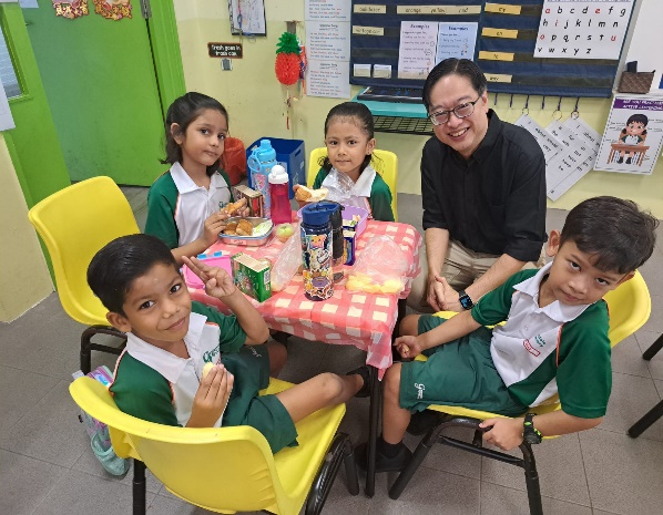 Vice Principal sharing a meal with students during a classroom lunch session.